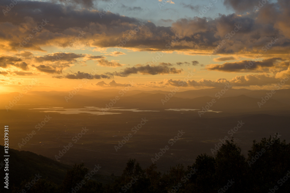 Autumn sunset light with clouds in blue sky with mountain landscape between the trees in horizontal HDR Autumn sunset light with clouds in blue sky with mountain landscape between the trees in horizontal HDR
