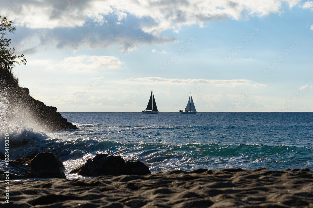 Two sailboats on the sea at sunset