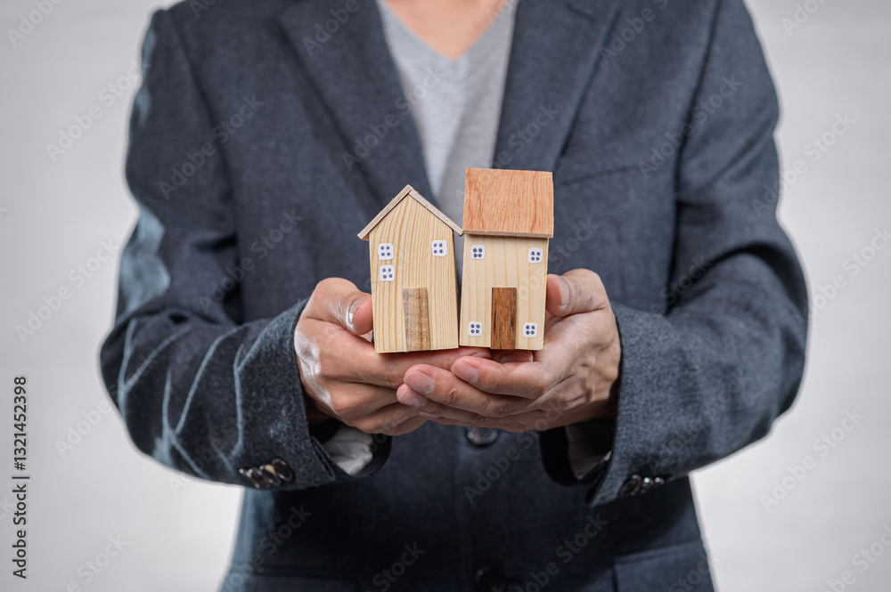 Businessman Holding Wooden Houses in Hands for Real Estate Concept Businessman Holding Wooden Houses in Hands for Real Estate Concept