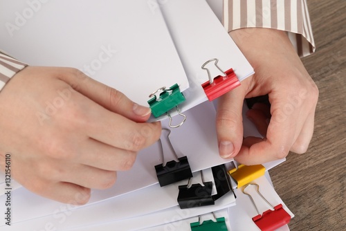 Wallpaper Mural Woman holding sheets of paper with metal binder clips at table, closeup Torontodigital.ca