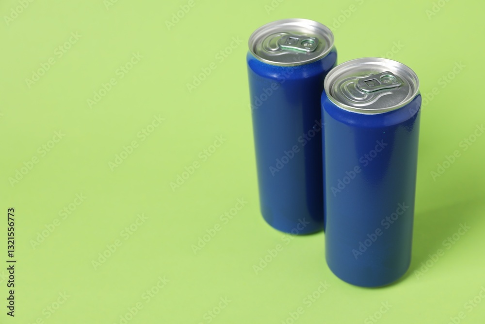 Two tin cans on light green background. Space for text Two tin cans on light green background. Space for text