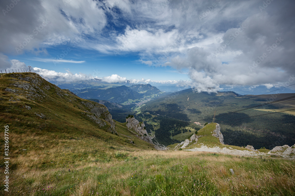 Fototapeta premium Breathtaking view of the Dolomites around Seceda, Sankt Christina, and Sankt Ulrich under a partly cloudy sky