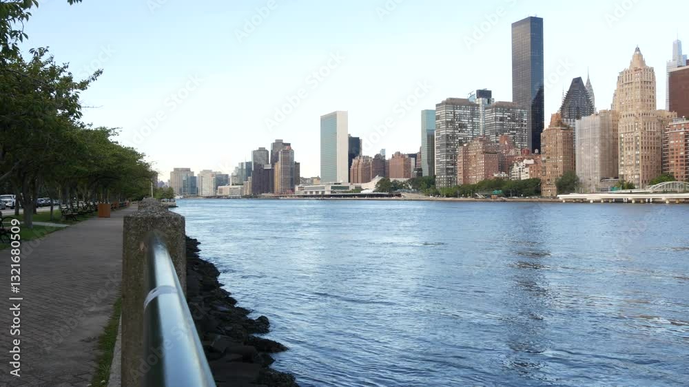 New York City waterfront skyline, Manhattan Midtown buildings, riverfront skyscrapers by East river water. Waterside cityscape view from Roosevelt Island. United States architecture and real estate. New York City waterfront skyline, Manhattan Midtown buildings, riverfront skyscrapers by East river water. Waterside cityscape view from Roosevelt Island. United States architecture and real estate.