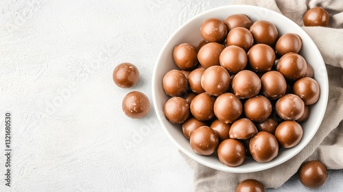 Obraz na płótnie Chocolate-covered maltesers are thoughtfully placed in a white bowl set on a grey surface, offering a minimalist aesthetic w salonie