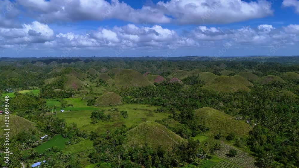Chocolate Hills in Bohol Philippines under a blue sky with lush green scenery Chocolate Hills in Bohol Philippines under a blue sky with lush green scenery