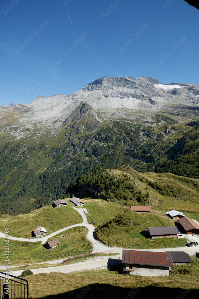 Fototapeta premium Scenic view from Hintertux Glacier showcasing alpine landscape and winding roads in Austria during a clear day