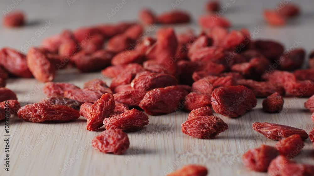 Dried goji berries in bowl and spoon on wooden table, closeup. Space for text Dried goji berries in bowl and spoon on wooden table, closeup. Space for text