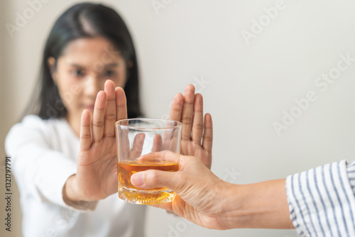 Alcoholism, depressed asian young woman hand refuse alcoholic beverage, drink whiskey while person holding glass give to her. Treatment of alcohol addiction, having suffered abuse problem alcoholism.