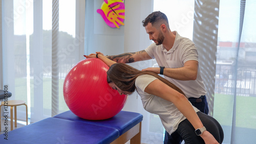 Obraz na płótnie Physiotherapist helps a young woman perform shoulder stretching exercises for rehabilitation w salonie