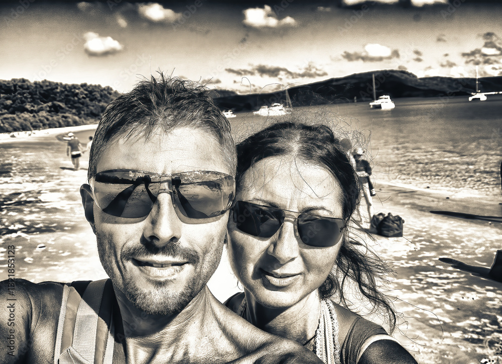 Selfie of a happy caucasian couple on vacation relaxing on a beautiful tropical beach