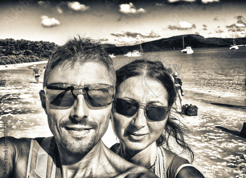 Obraz na płótnie Selfie of a happy caucasian couple on vacation relaxing on a beautiful tropical beach w salonie