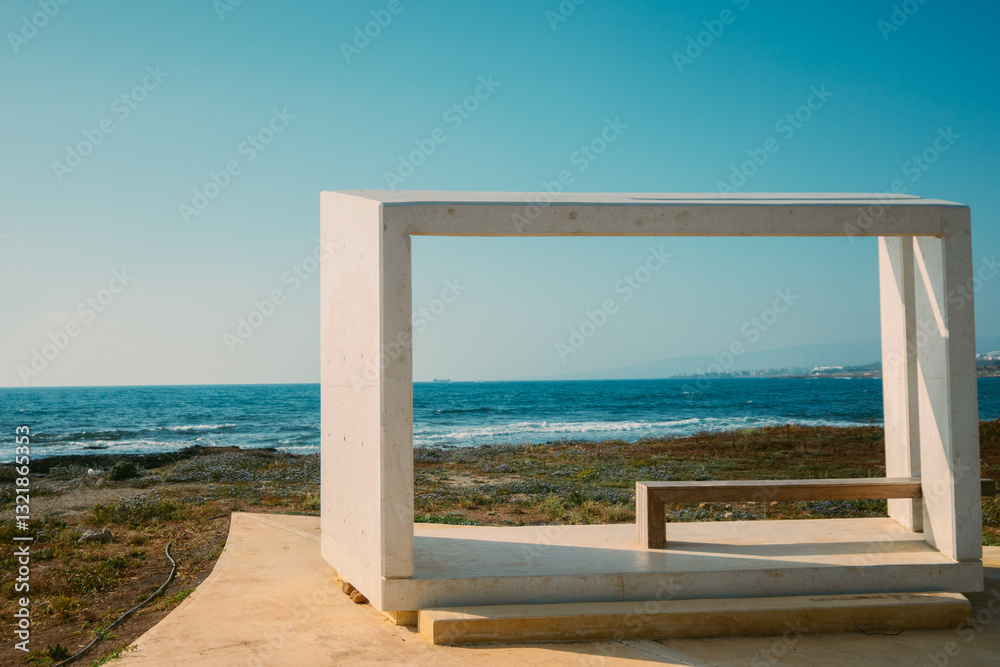 Paphos waterfront, Cyprus. A cubic white bench with modern architecture set against the deep blue Mediterranean Sea. A concept of paradise vacation, Mediterranean landscapes of Cyprus and Greece Paphos waterfront, Cyprus. A cubic white bench with modern architecture set against the deep blue Mediterranean Sea. A concept of paradise vacation, Mediterranean landscapes of Cyprus and Greece