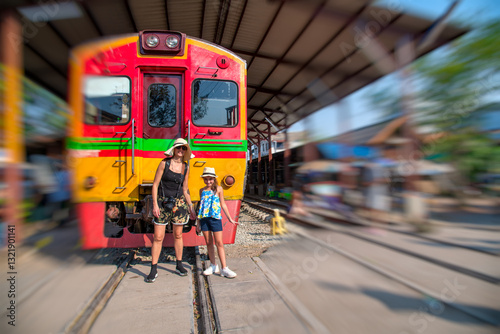 Obraz na płótnie Mother and daughter exploring Maeklong Train Station, a unique tourist attraction in Thailand w salonie