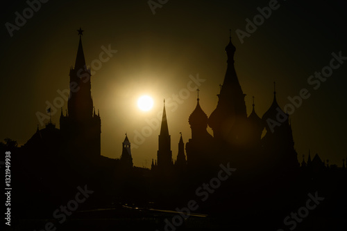 Obraz na płótnie Silhouette of Moscow at sunset, Russia. Kremlin and St Basil's Cathedral against sun in evening, landmarks of city center in sunlight, concept of skyline and travel w salonie