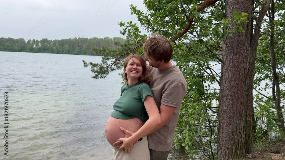beautiful couple, husband and pregnant wife in nature hugging against the background of a lake in warm weather, future parents beautiful couple, husband and pregnant wife in nature hugging against the background of a lake in warm weather, future parents