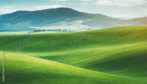Gentle green hills stretch beneath a clear sky, offering a tranquil, minimalist landscape bathed in soft light