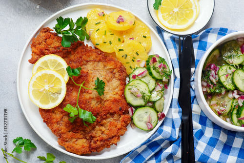 Photography Traditional Viennese schnitzel on a plate with cucumber and potato salad