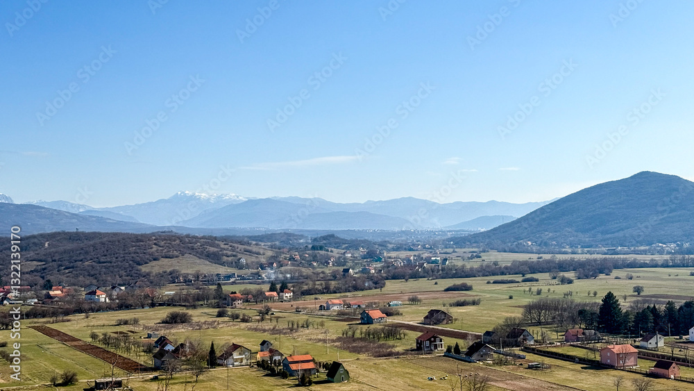 Obraz premium Peaceful rural landscape with mountains in the background, perfect for summer retreats and nature escapes
