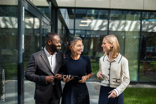 Diverse business team walking outside modern office building