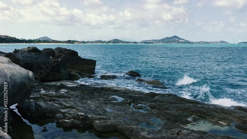 The restless waves of the Gulf of Thailand beat against the rocks