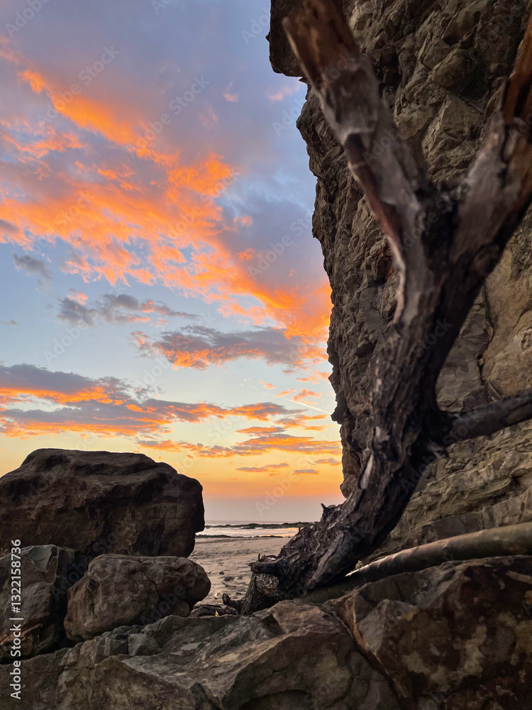 sunset on the coast of Nicaragua with bright orange clouds that we can see behind the cliff