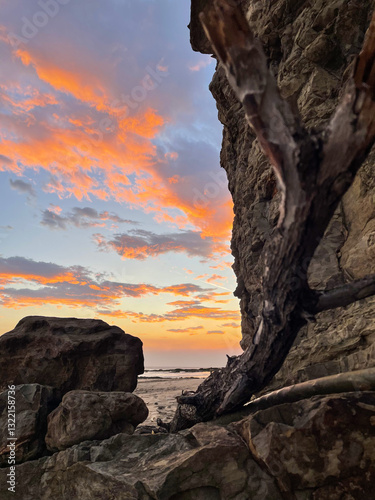 Obraz na płótnie sunset on the coast of Nicaragua with bright orange clouds that we can see behind the cliff w salonie