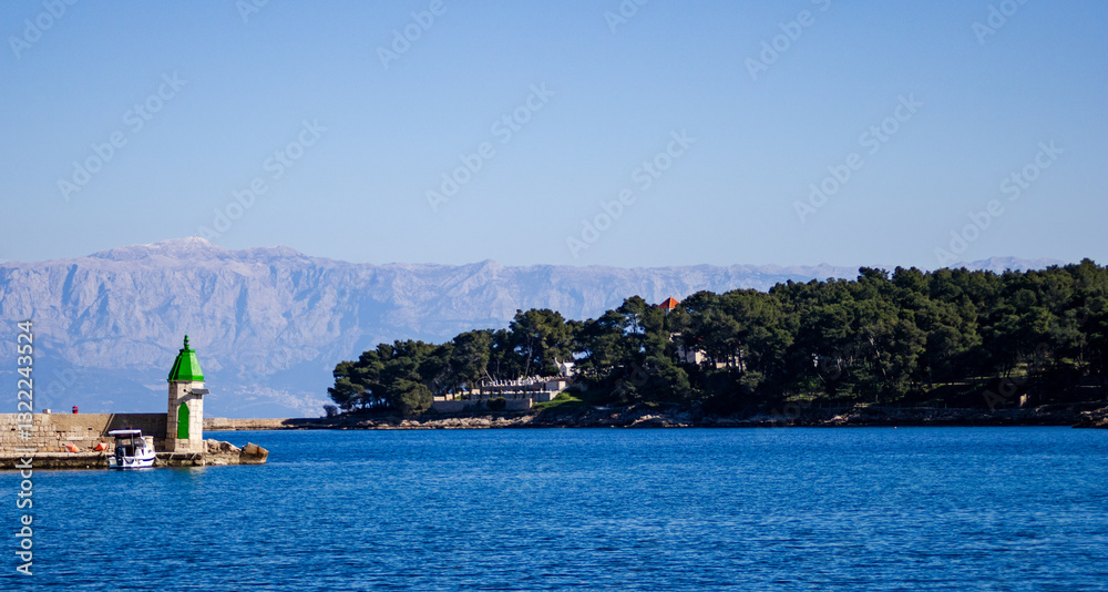 Naklejka premium Lighthouse at breakwater in harbor Jelsa,Hvar island, Croatia.
