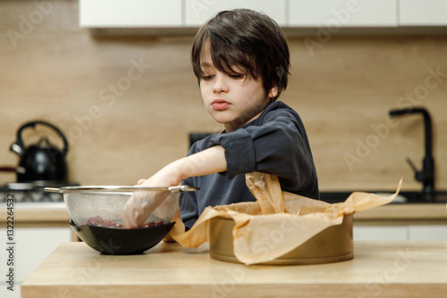 Mother and son are preparing a cherry cake together