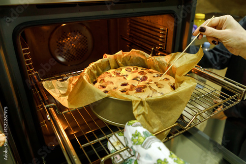 Mother and son are preparing a cherry cake together