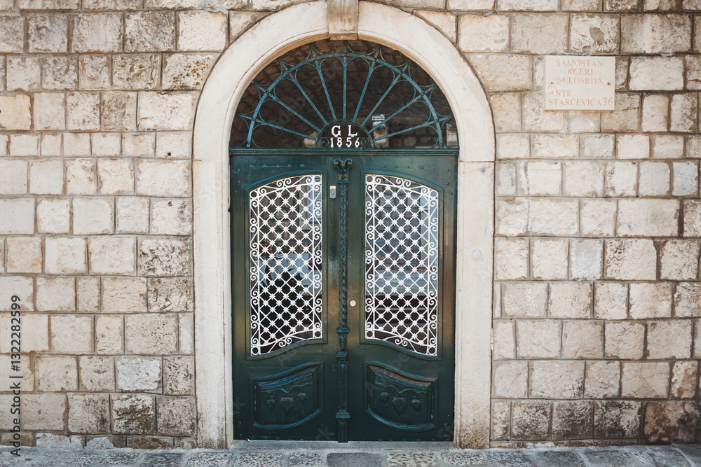 Bright green doors in the historic stone wall of the Old Town in Croatia.
