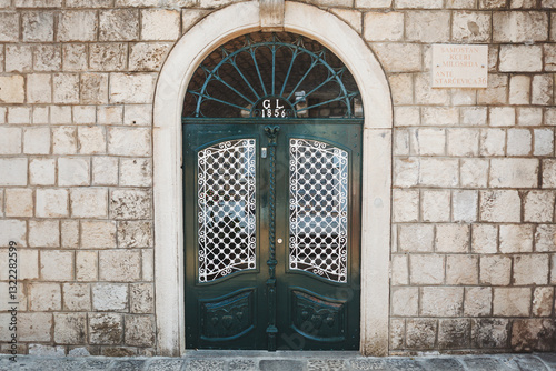 Bright green doors in the historic stone wall of the Old Town in Croatia.