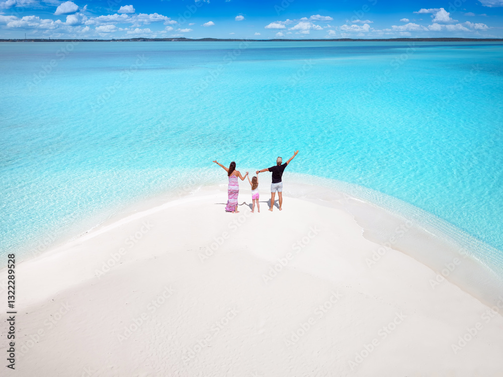 Aerial view of a happy family standing on a tropical paradise beach and enjoying their vacatios in the Caribbean Sea
