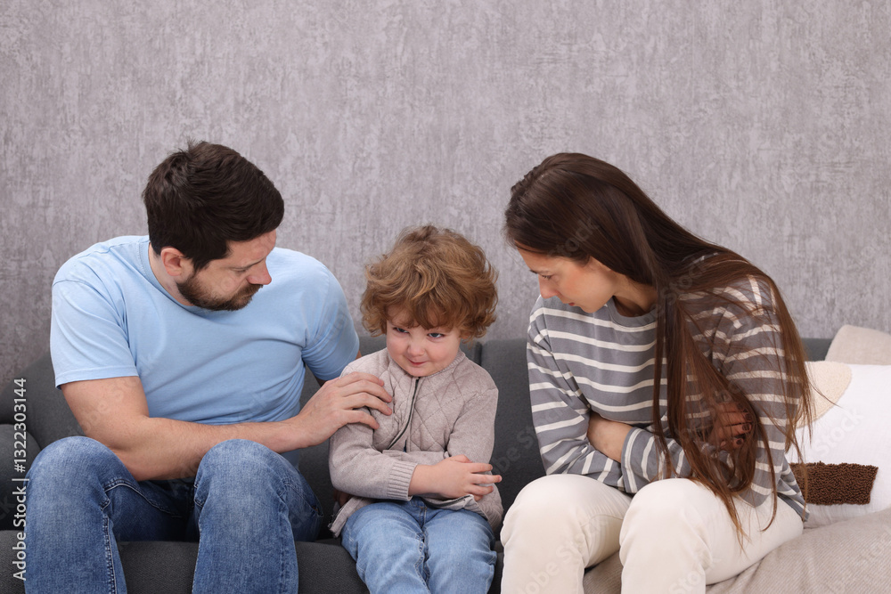 Resentful little boy and his parents arguing at home Resentful little boy and his parents arguing at home