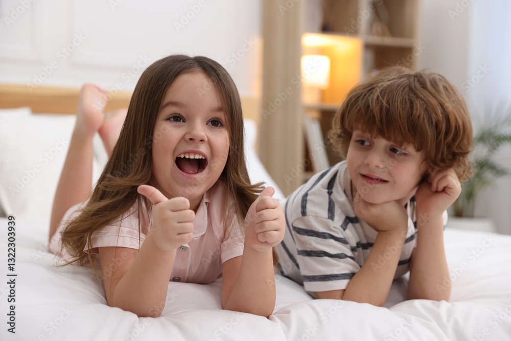 Happy children wearing pajamas on bed at home Happy children wearing pajamas on bed at home