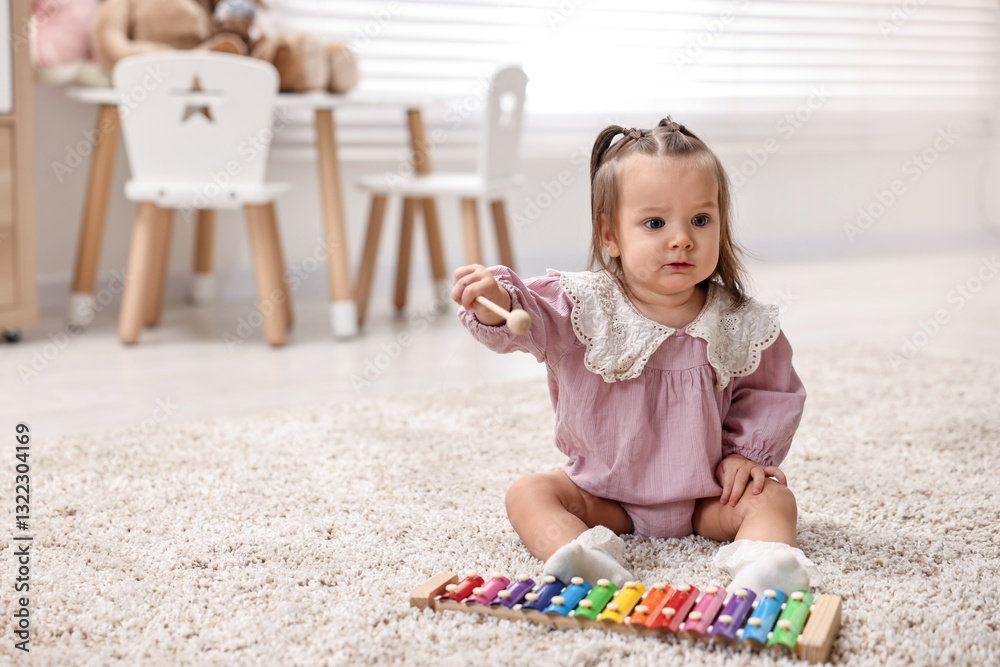 Cute little girl playing with toy xylophone on floor at home, space for text Cute little girl playing with toy xylophone on floor at home, space for text