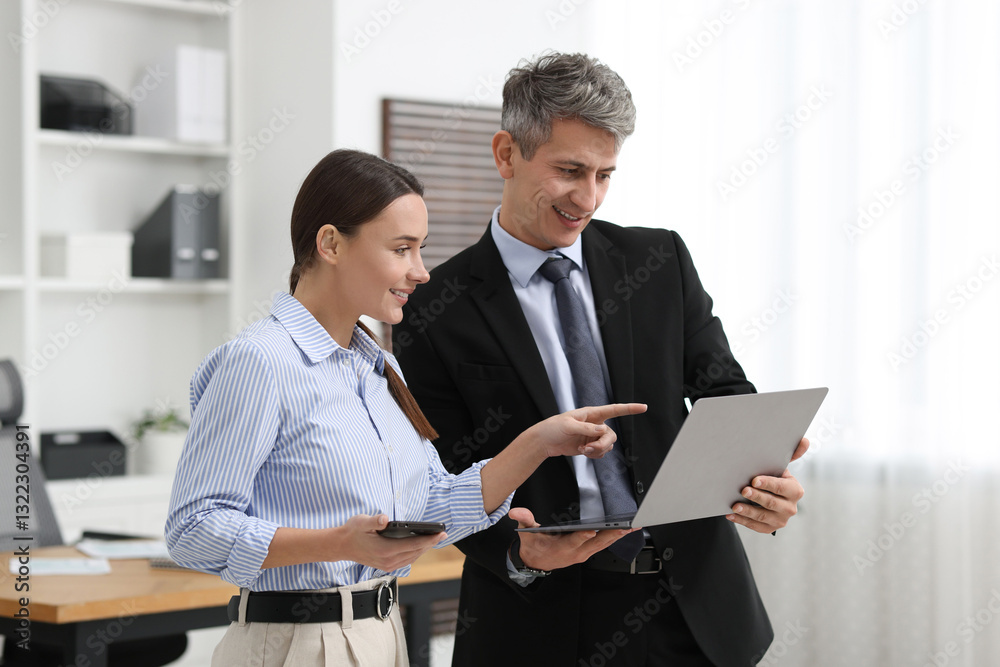 Coworkers with laptop working together in office Coworkers with laptop working together in office