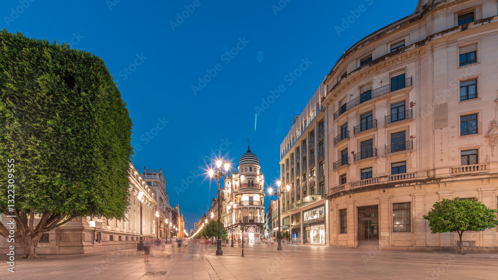 Naklejka premium Illuminated Adriatica building on Avenida de la Constitucion at night, Seville, Spain