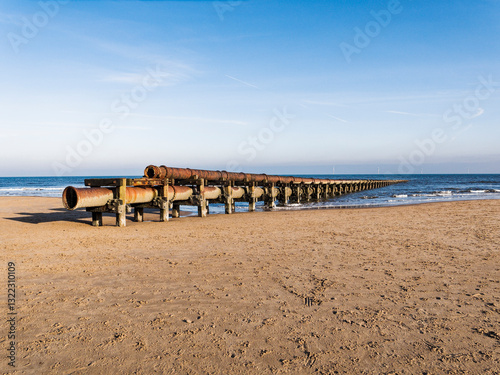 Old broken and rusted pipe leading into the sea with copy space.