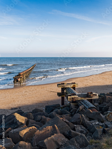 Old broken and rusted pipe leading into the sea with copy space.