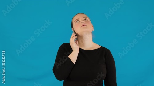 Woman tilts phone away from ear during phone conversation. Lady tries to distance from caller voice showing irritation during conflict situation