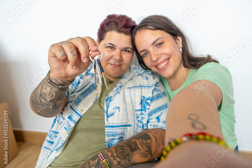 Happy lesbian friends celebrates new home with keys and smiles