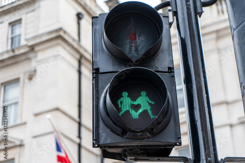 Wallpaper Mural A pedestrian traffic light in London displays a green signal with two figures holding hands and a heart symbol. A historic building and a British flag are visible in the background. Torontodigital.ca