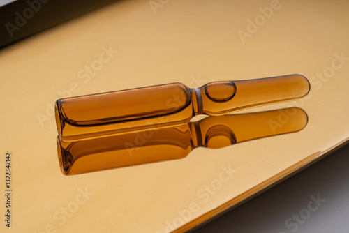 Cosmetic ampoules with anti-aging serum on a reflective surface