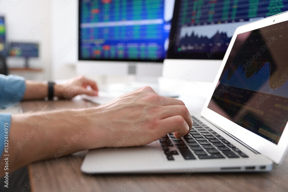 Financial trading specialist working on laptop at table in office, closeup Financial trading specialist working on laptop at table in office, closeup