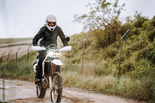 Obraz na płótnie Motorista creando contenido en dia lluvioso en camino de barro inundado w salonie