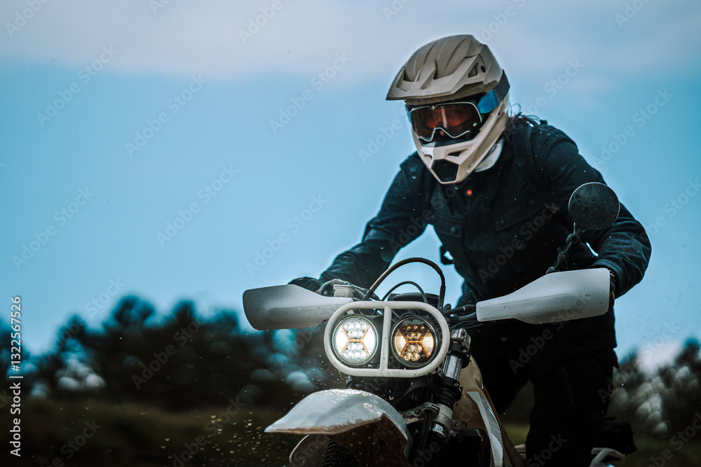 Motorista creando contenido en dia lluvioso en camino de barro inundado