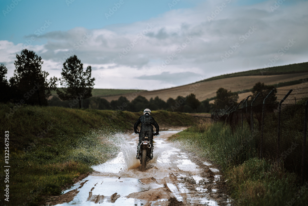 Motorista creando contenido en dia lluvioso en camino de barro inundado