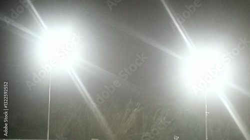Bright stadium lights illuminating foggy night