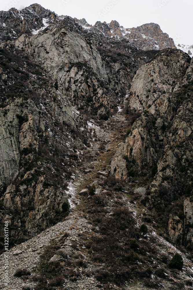 Stunning landscape of rocky mountains in Kyrgyzstan with a winding path through the rugged terrain Stunning landscape of rocky mountains in Kyrgyzstan with a winding path through the rugged terrain