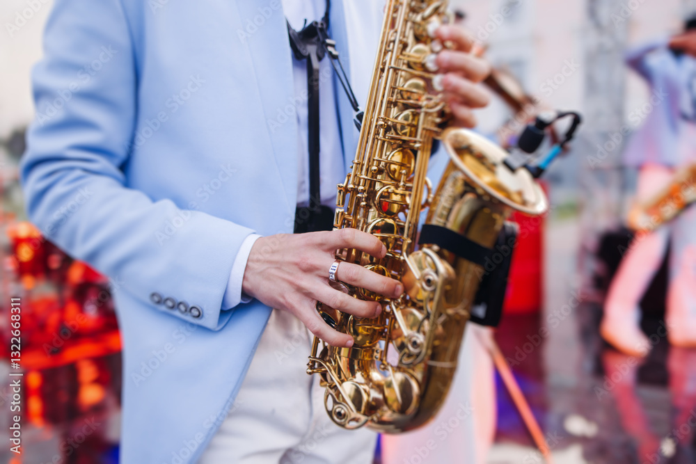 Fototapeta premium Concert view of saxophonist musician, saxophone sax player with vocalist and musical band during jazz orchestra show performing music on a stage in the scene lights, concert in a musical club hall